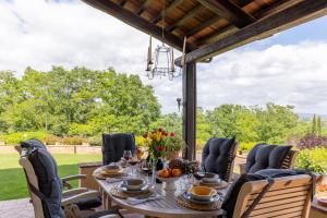 a dining room with a table and chairs on a patio at Villa Sabrina by PosarelliVillas in San Gimignano