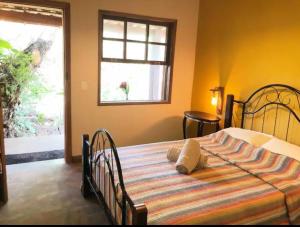 a bedroom with a bed in a room with a window at Chalé da Serra in Brumadinho