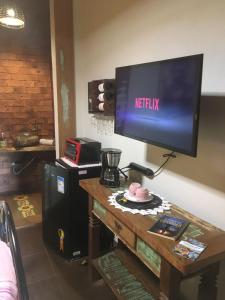 a television on top of a table with a tableablishthritisthritis at Chalé da Serra in Brumadinho