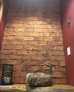 a brick wall with a picture in front of it at Chalé da Serra in Brumadinho