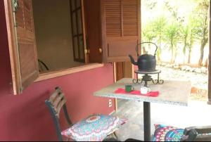 a kitchen with a table and a tea kettle on it at Chalé da Serra in Brumadinho