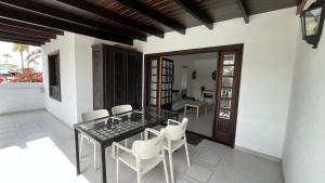 a dining room with a glass table and white chairs at Casa Minerva in Costa Teguise