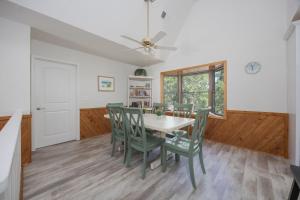 a dining room with a table and green chairs at 2507 - Salty Sandpiper in Duck +30 photos