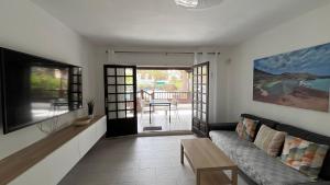 a living room with a couch and a television at Casa Minerva in Costa Teguise