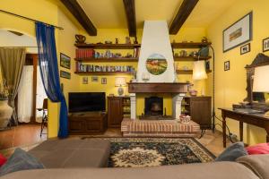 a living room with a fireplace and a tv at Villa Sabrina by PosarelliVillas in San Gimignano
