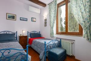 a bedroom with a bed and a chair and a window at Villa Sabrina by PosarelliVillas in San Gimignano +28 photos