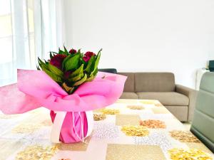 a pink vase with a pink flower on a table at Sole e Luna in San Vito