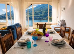 a table with a bowl of fruit and wine glasses at Botanic Garden Lake Como in Blevio