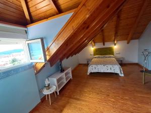 a bedroom with a bed in a room with wooden ceilings at Hostería La Casona in Noja