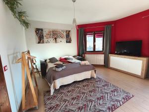 a bedroom with a bed and a red wall at Monolocale moderno in centro storico in Scano Montiferro