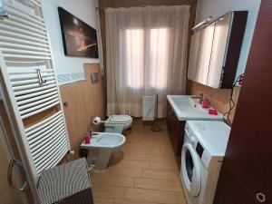 a small bathroom with a toilet and a sink and a toilet istg at Monolocale moderno in centro storico in Scano Montiferro +6 photos