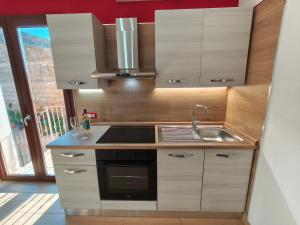a kitchen with a sink and a stove at Monolocale moderno in centro storico in Scano Montiferro
