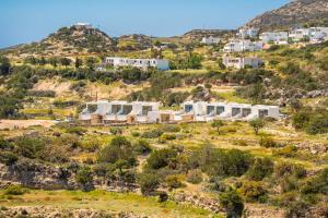 a cluster of white buildings on a hill at Ramnus Karpathos Suites in Karpathos +81 photos