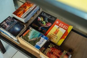 a table topped with books and magazines at Aru House Ubud in Ubud