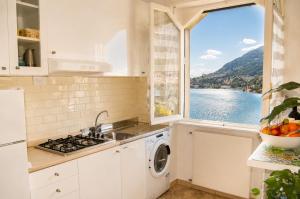 a kitchen with a window with a view of the water at Botanic Garden Lake Como in Blevio +27 photos