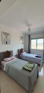 two beds in a room with two beds sidx sidx sidx at Duplex La roseraie à 2min de la plage 2 piscines in Sidi Bouzid