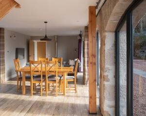 a dining room with a wooden table and chairs at Remore Steading - The Coach House in Ardclach +47 photos