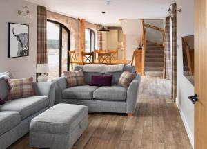 a living room with a couch and a table at Remore Steading - The Coach House in Ardclach