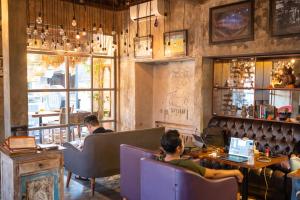 a group of people sitting in a restaurant with laptops at Aru House Ubud in Ubud