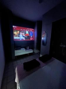 a living room with a tv in a dark room at Suíte Sete Colinas in Garanhuns