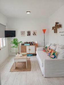 a white living room with a white couch and a table at La Casita de Suances 1- Jardín y Parking, Ideal Familias y Mascotas in Suances