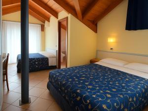 a bedroom with two beds and a table and chairs at Smart Rooms Miramare in Sottomarina