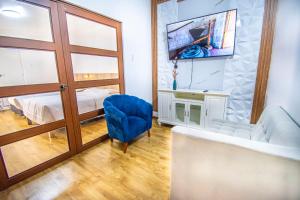 a living room with a blue chair and a tv at Alpacasa Arequipa in Arequipa
