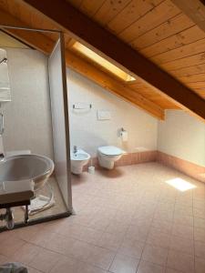 a bathroom with a tub and a toilet and a sink at Smart Rooms Miramare in Sottomarina