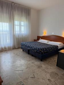a bedroom with a bed and a large window at Smart Rooms Miramare in Sottomarina +17 photos