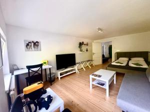 a living room with a couch and a tv at Ferienwohnung Huskyhausen - Schlittenhunde Erlebnisse & Urlaub mitten in der Natur! in Klaffer am Hochficht