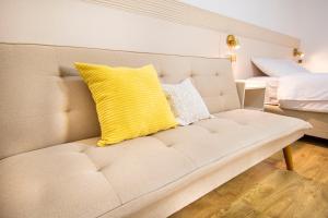 a couch with a yellow pillow on it in a room at Alpacasa Arequipa in Arequipa