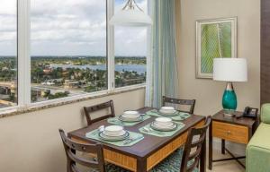 a dining room with a table and chairs and windows at Hollywood Beach Tower - Hotel Room in Hollywood +11 photos