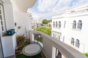 a balcony with a table and chairs on a building at Royal Moroccan Suite Central Tangier in Tangier