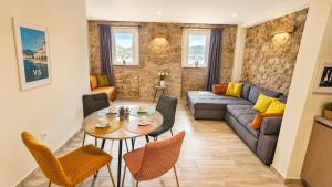 a living room with a couch and a table and chairs at Haven Bay Apartment in Rogotin