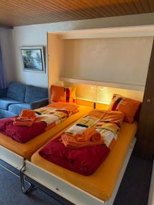 two beds in a room with a couch at Gonenstein 11 in Leukerbad