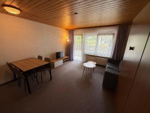 a living room with a table and chairs and a television at Gonenstein 11 in Leukerbad