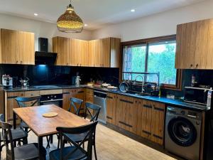 a kitchen with a wooden table and a dining room at Le Forestier in Dar el Hajri +31 photos