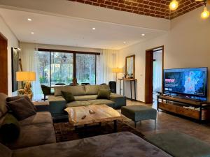 a living room with a couch and a flat screen tv at Le Forestier in Dar el Hajri