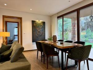 a living room with a wooden table and chairs at Le Forestier in Dar el Hajri