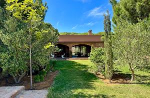 a house with a garden and trees in front of it at Le Forestier in Dar el Hajri