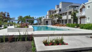 a swimming pool in front of a building at Refugio de Mar in Miramar