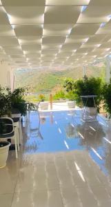 a room with a pool with chairs and plants at Astoria Rooms in Sarandë
