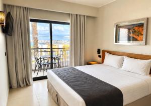a hotel room with a bed and a balcony at Vitors Village in Ferragudo +44 photos