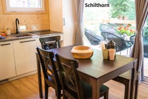 a kitchen with a wooden table with chairs and a window at Camping Jungfrau in Lauterbrunnen