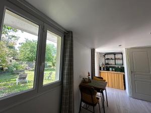 a kitchen with a table and a large window at Le Cerisier in Giverny