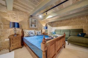 a bedroom with a bed and a couch in a room at Valletta Boutique Residence in Valletta