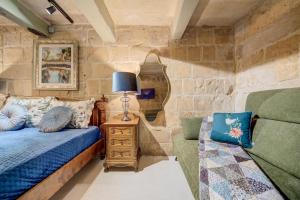 a room with a bed and a couch and a lamp at Valletta Boutique Residence in Valletta