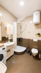 a bathroom with a toilet a sink and a tub at Haven Bay Apartment in Rogotin +31 photos