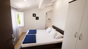 a bedroom with a bed with white sheets and a window at Haven Bay Apartment in Rogotin