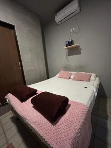 a bedroom with a bed with two pillows on it at Suíte Sete Colinas in Garanhuns +2 photos
